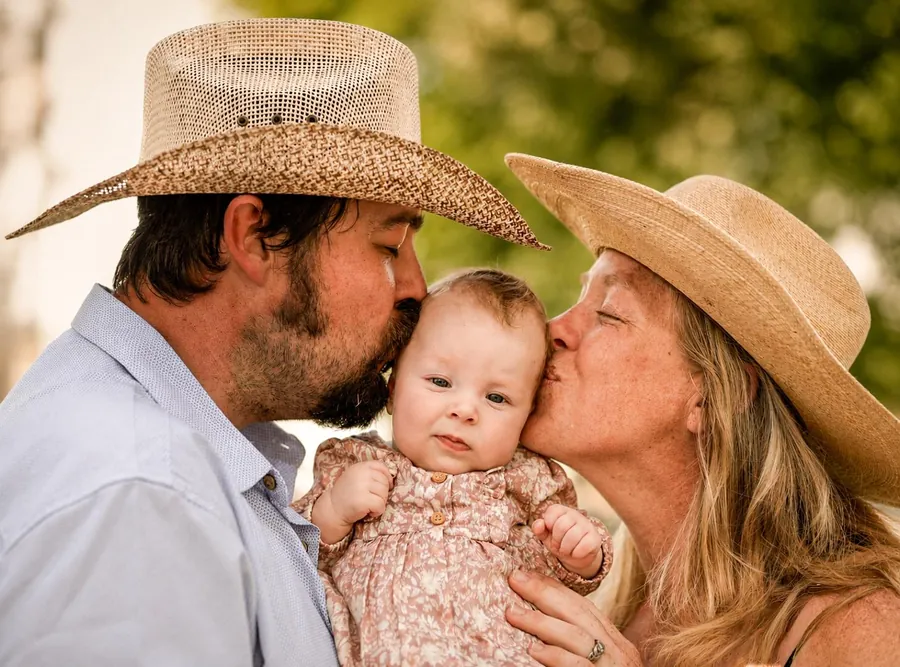 Family session, parents kissing their baby