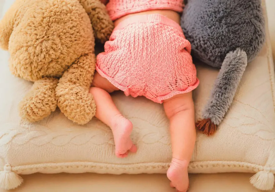 Newborn nestled with plush toys