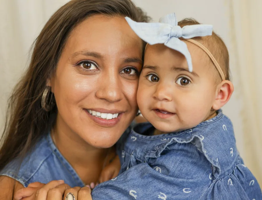 Mother and baby girl cheek to cheek in matching denim