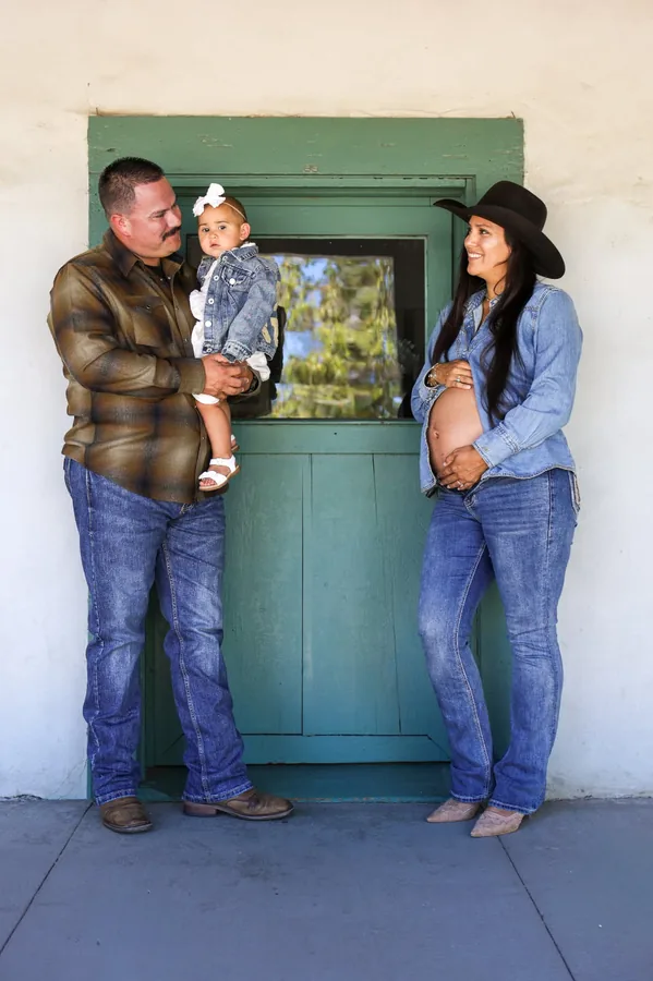 Maternity family portrait by the green ranch door