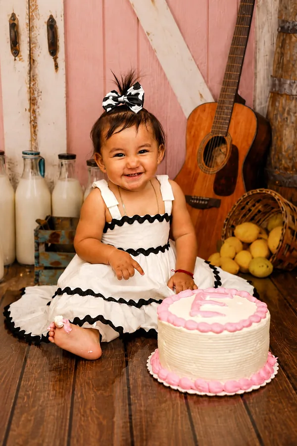 First birthday session against a pink barn door with milk bottles